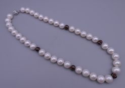 An 18 ct white gold diamond section and pearl necklace. 46 cm long.