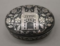 An Eastern unmarked silver inlaid iron box. 10.5 cm wide.
