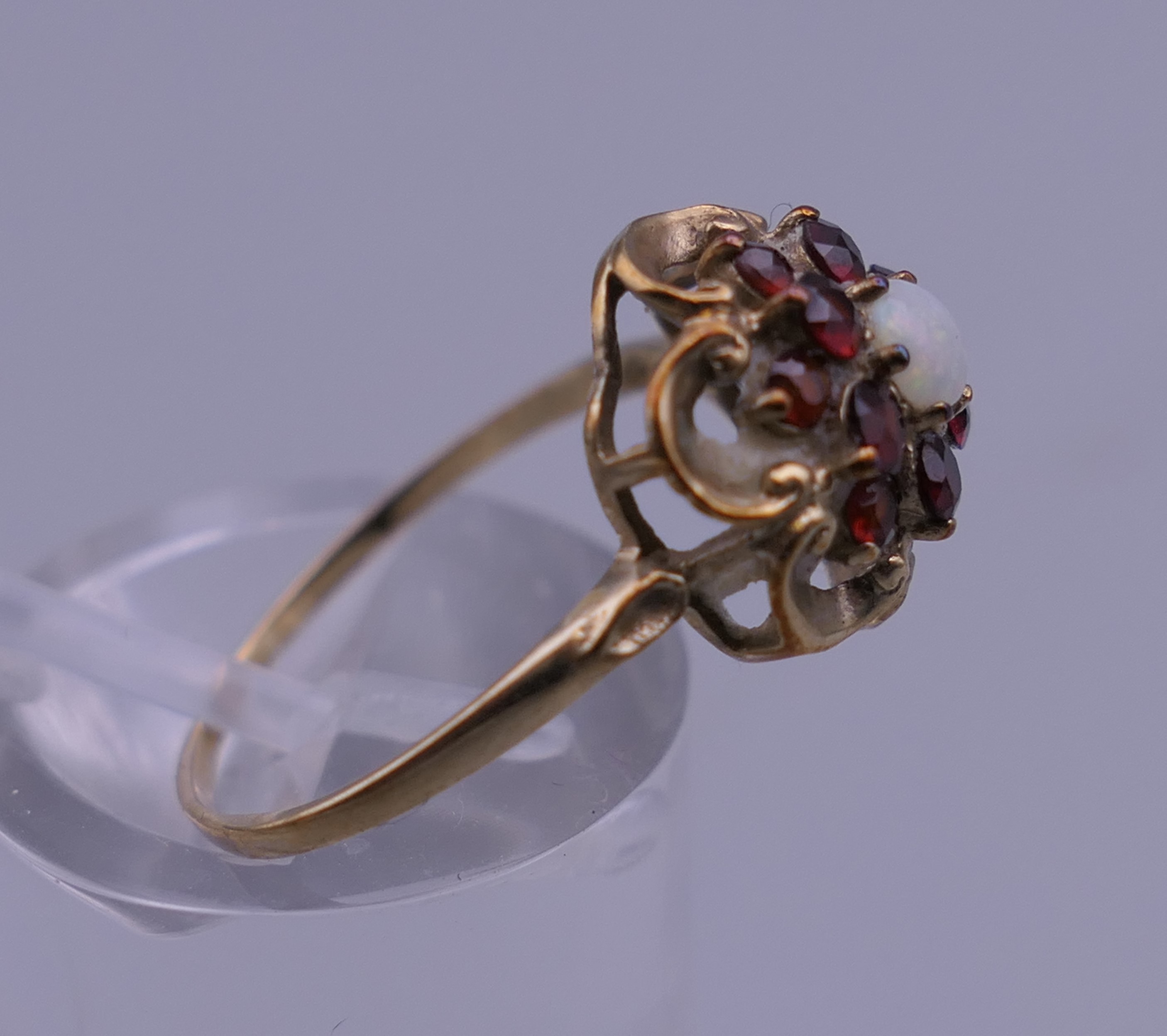 An unmarked 9 ct gold garnet and opal ring. Ring size M. 1.6 grammes total weight. - Image 2 of 4