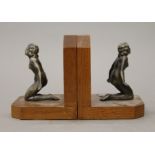 A pair of Art Deco bookends, each surmounted with a nude female. 12.5 cm high.