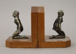 A pair of Art Deco bookends, each surmounted with a nude female. 12.5 cm high.