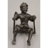A bronzed figure of a man on a swing. 12 cm high.