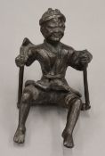 A bronzed figure of a man on a swing. 12 cm high.