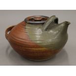 A hand thrown teapot, indistinct potters mark under spout, possibly MU, possibly 1960's/70's.