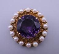 A 9 ct gold amethyst and seed pearl brooch. 3 cm diameter. 10.4 grammes total weight.