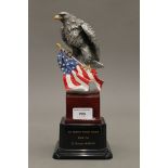 An eagle and flag on stand presented to the Yeoman Warders from the US Element Marcom. 28 cm high.