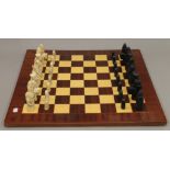 A large chess board and chess set. The board 59 cm wide. The Kings 9.5 cm high.