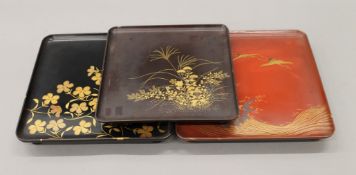 Three Japanese lacquered trays. The smallest 24 cm square.
