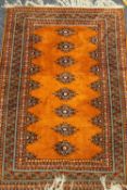 An orange ground wool rug. 183 x 126 cm.
