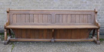A Victorian Arts and Crafts carved oak pew. 235 cm long.