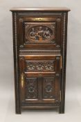 A 19th century carved oak cupboard. 66.5 cm wide.