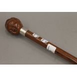 A walking stick with carved nut form handle with glass inset eyes. 83 cm long.