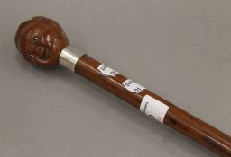 A walking stick with carved nut form handle with glass inset eyes. 83 cm long.