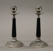 A pair of Oriental silver and ebony candlesticks. Each 19 cm high.