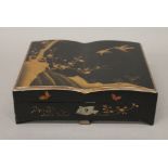 A late 19th/early 20th century Japanese lacquered games box, containing bone and ivory counters.