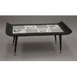 A mid-19th century black coffee table with black and white tiles including four picture tiles,