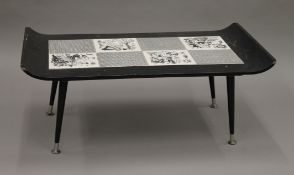 A mid-19th century black coffee table with black and white tiles including four picture tiles,