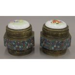 A pair of Chinese cloisonne decorated octagonal pots with porcelain lids decorated with figures,