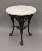 A Victorian cast iron Britannia pub table with marble top. 74 cm high.