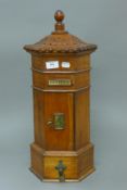 A wooden post box. 56 cm high.