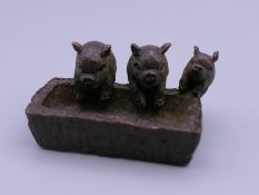 A bronze model of pigs at a trough. 4.5 cm wide.
