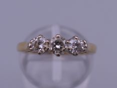 An 18 ct gold diamond three stone ring. Ring size G/H. 3.9 grammes total weight.