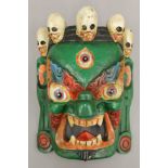 A Tibetan painted wooden mask. 31 cm high.