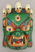 A Tibetan painted wooden mask. 31 cm high.