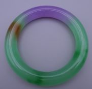 A multi-coloured jade bangle. 8.5 cm outer diameter, 6 cm inner diameter.