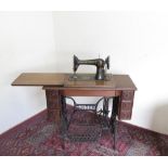 Singer sewing machine and table with cast metal base and drawers to the side