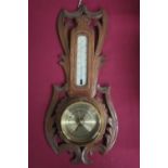 20th C aneroid barometer and thermometer in carved a pierced soft wood surround H40cm