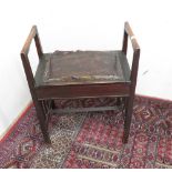 Art nouveau style ebonised piano stool with raised side arms and lift up seat, on square supports