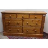 Pine chest of three short and four deep drawers, with turned wooden handles, on plinth base