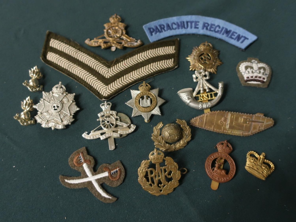 Collection of metal and cloth badges, mainly British, including paratrooper regiment shoulder