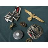Collection of German metal badges including Iron Cross, tank corp badge, eagle cap badge, etc (7)