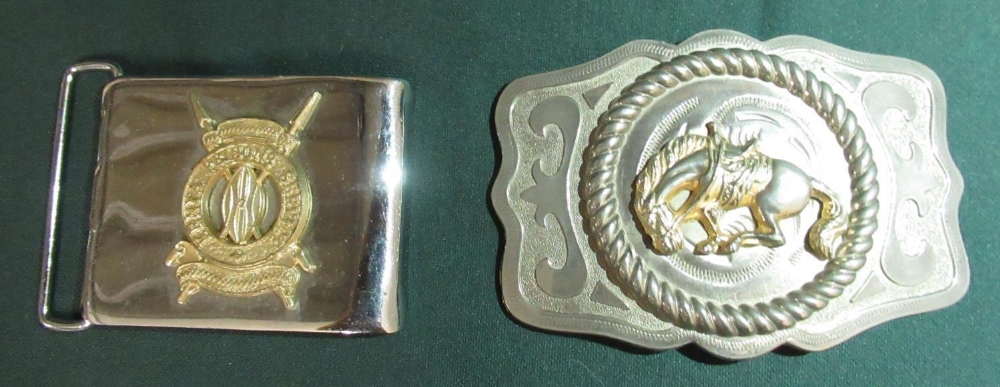 Metal belt buckle with a bucking bronco and a belt buckle with the badge of the Kenyan Prisons