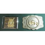 Metal belt buckle with a bucking bronco and a belt buckle with the badge of the Kenyan Prisons