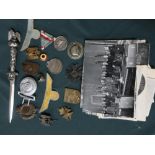 Collection of German WWII badges and insignia including a belt buckle, SS ring, eagle on Swastika