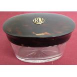 Edwardian clear glass oval dressing table jar, tortoiseshell top relief decorated with gold coloured