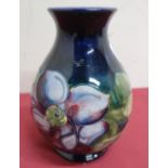 Moorcroft pottery vase, the baluster body decorated with a clematis pattern on a blue ground,