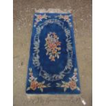 Chinese embossed washed woolen rug, blue ground with central floral medallion and floral pattern