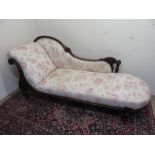 Victorian mahogany chaise lounge, frame carved with flowers and scrolls, on turned tapering supports