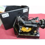 Small Singer portable electric sewing machine No.221K with foot pedal control and instructions book,