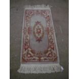 Chinese washed woolen rug, beige ground with central floral pattern and floral patterned border,