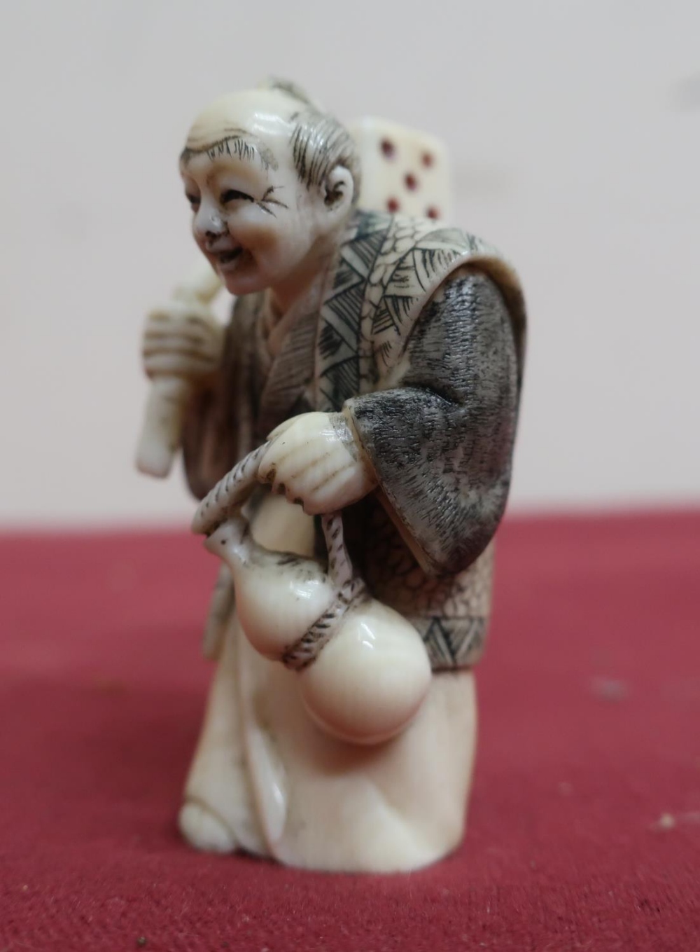 Small late 19th C carved ivory Okimono of a figure carrying a dice, with scratched decoration, - Image 3 of 4