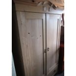 Craftsman made pine wardrobe with arched cornice, two panel doors above one drawer on bun turned