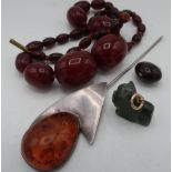 Single string of graduated dark amber beads L44cm (A/F), a 20th C amber stylised hat pin, jade