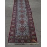 20th C traditional pattern wool and acrylic runner, eight central medallions with red stylized