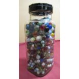 Confectioners glass storage jar containing a selection of marbles of different designs and sizes