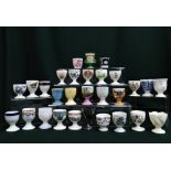 Collection of egg cups by New Chelsea, Shelley, Royal Crown Derby, Spode, Wedgwood, Coalport,